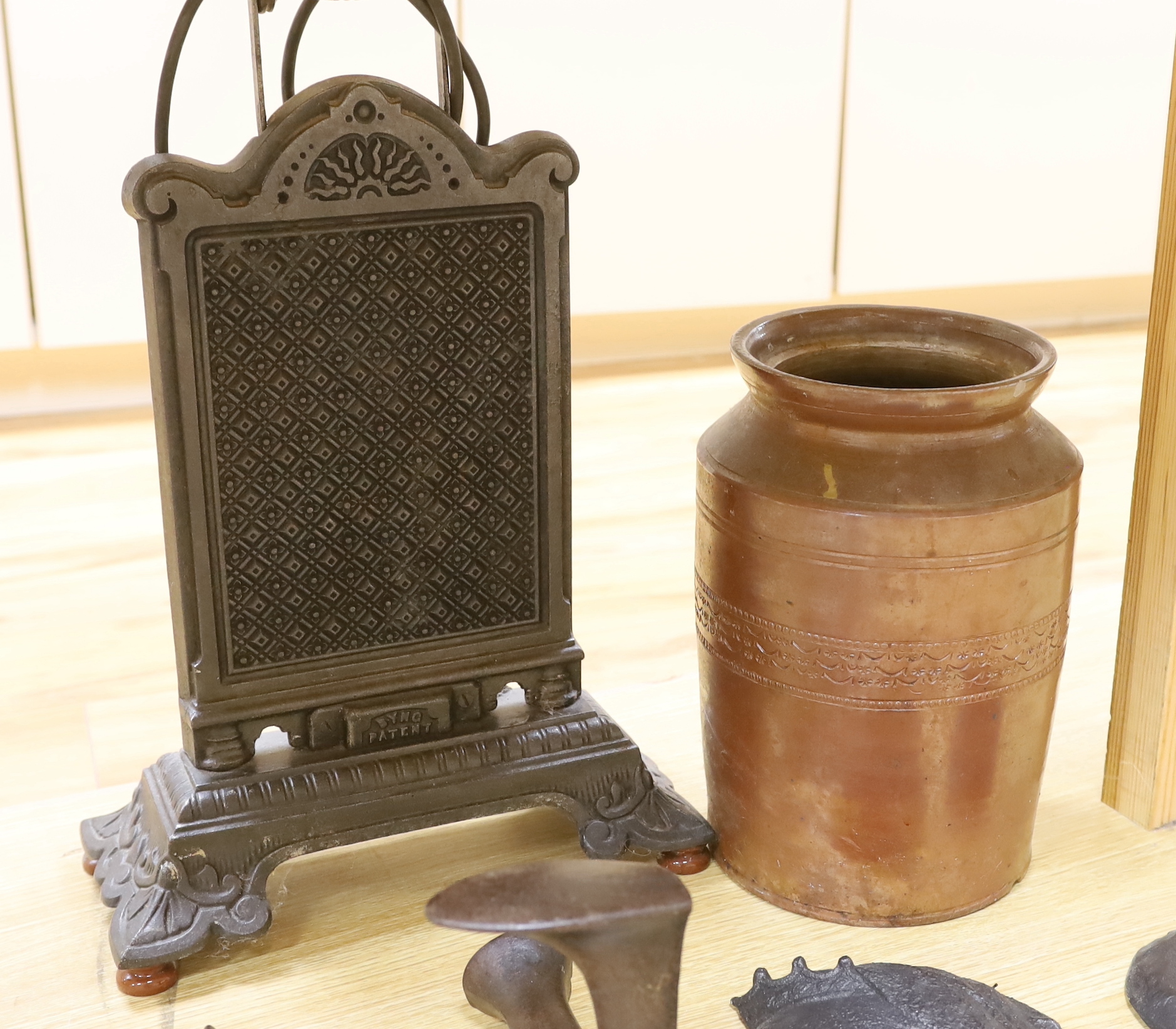 Metalware comprising wrought iron heater, two metal plaques including one of Queen Victoria, boot makers anvil, and a stoneware vase, the largest 53cm high